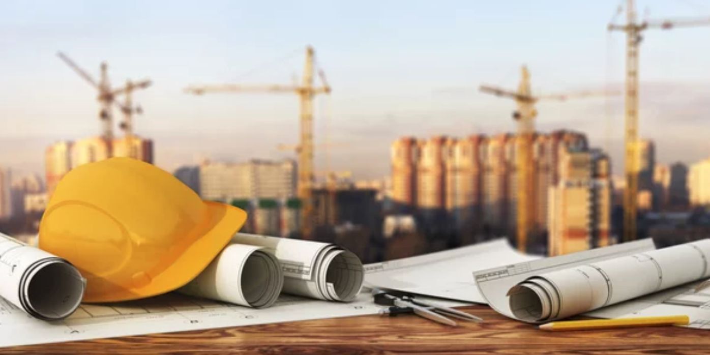 Hard hats and blueprints at construction site