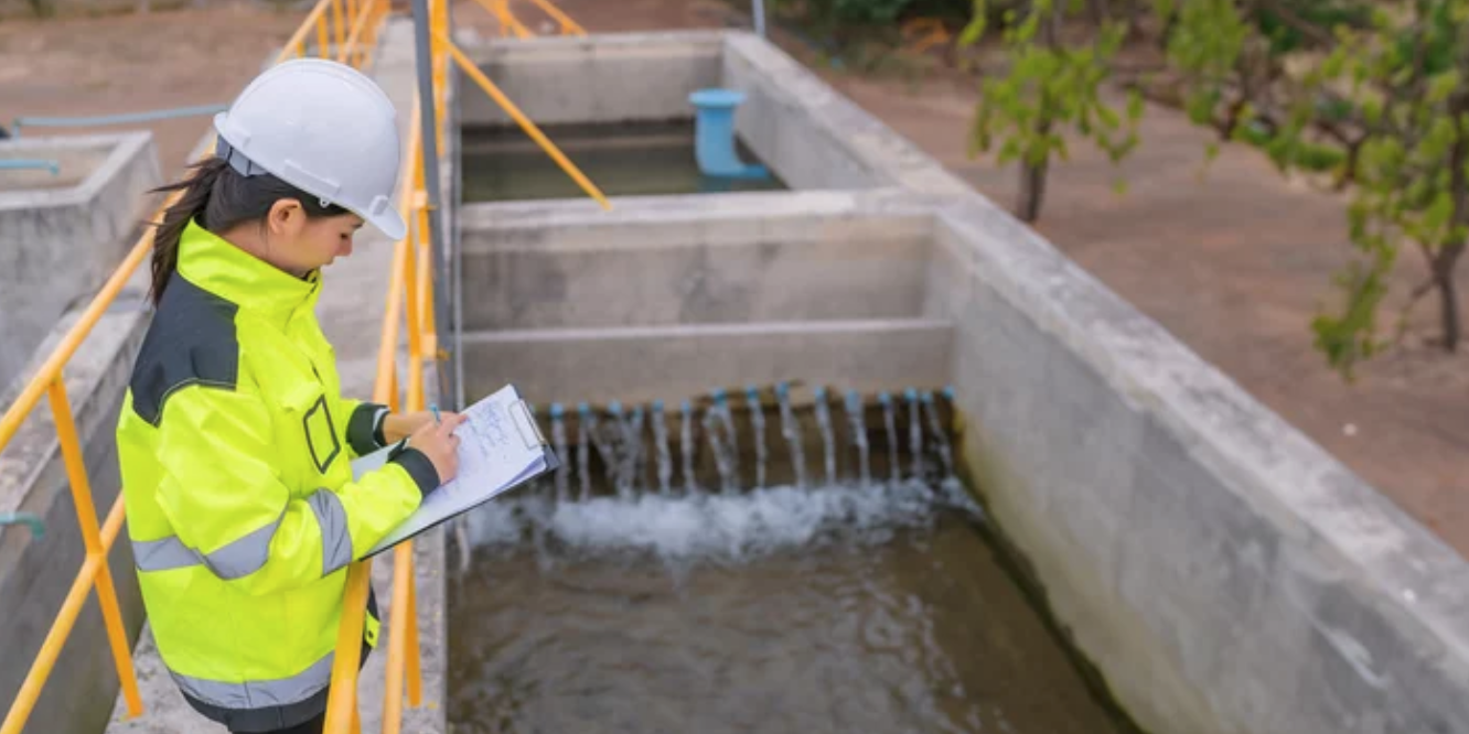 Woman standing at sanitation/clean water facility.